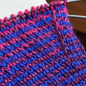 Back of a sock in progress in blue, pink, and purple - showing the beginning of a gusset.